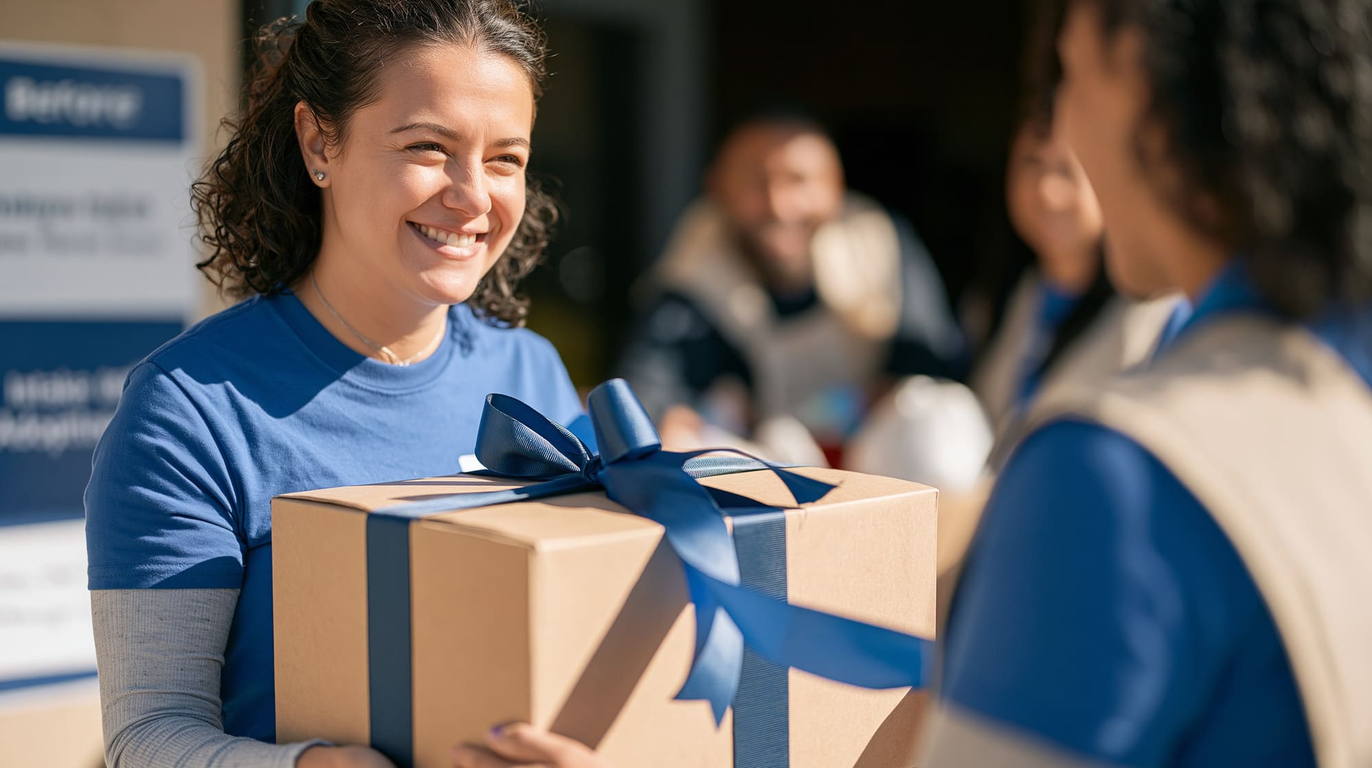 Bénévole souriante offrant un cadeau à une personne, illustrant le partage, la générosité et l’importance de recevoir.