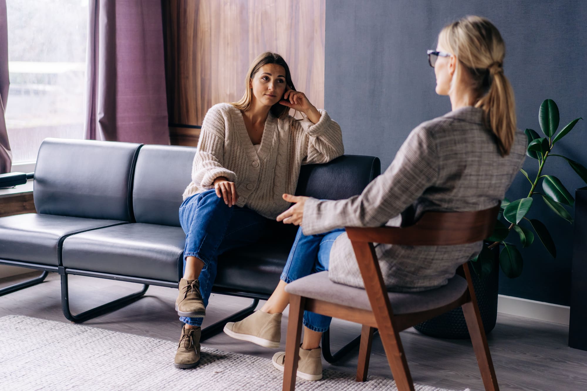 Thérapeute en relation d’aide en consultation avec une cliente dans un bureau, lors d’un échange axé sur l’écoute, le soutien émotionnel et le développement personnel.